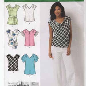 May include: Simplicity sewing pattern 2594, featuring various blouse designs. The pattern includes illustrations of tops in green, white, floral, pink, black and blue. The model is wearing a black and white checkered top and white pants. The text "easy-to-sew" is visible.