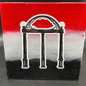 May include: A red, white, and black canvas painting featuring a black silhouette of the iconic archway known as the "Arch" at the University of Georgia.
