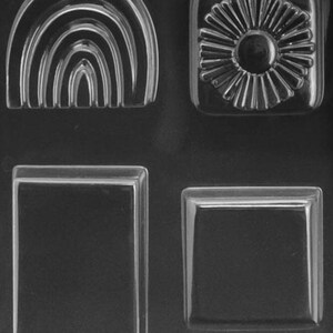 May include: A clear plastic mold with four different shapes: a rainbow arch, a flower, and two rectangles. The mold is designed for making soap, resin, or other crafts.