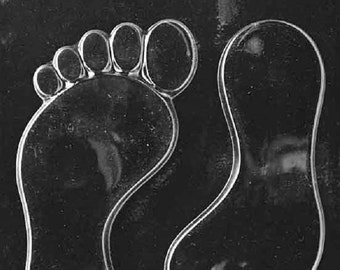 May include: A clear plastic mold for making chocolate baby footprints. The mold has two footprints, each with five toes.