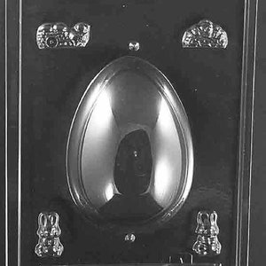 May include: A clear plastic mold for making chocolate Easter eggs. The mold has two bunny shapes and two small car shapes on the sides. The center of the mold is a large oval shape for the egg.