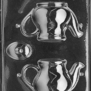 Może przedstawiać: Przezroczysta plastikowa forma do robienia czekoladek lub cukierków w kształcie czajniczka. Forma zawiera dwa czajniczki, jeden z pokrywką i oddzielną formę na pokrywkę. Projekt jest szczegółowy.