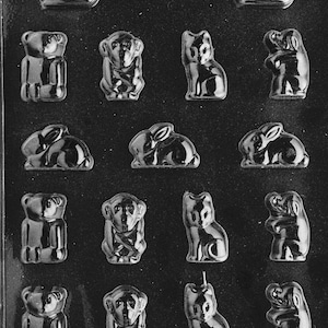 Pode incluir: Um molde de plástico transparente com várias formas de animais, incluindo patos, ursos, macacos, gatos e coelhos. O molde é projetado para criar chocolates ou doces. O texto "LIFE OF THE PARTY" é visível na parte inferior.