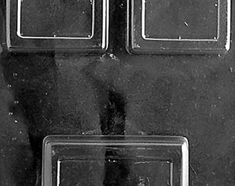 Puede incluir: Un molde de plástico transparente con tres cavidades rectangulares. Dos cavidades cuadradas en la parte superior y una cavidad rectangular más grande en la parte inferior. El molde está diseñado para crear artículos con forma.