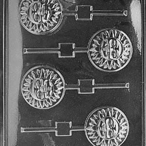 Puede incluir: Molde de plástico transparente para hacer piruletas o bombones con forma de sol. El molde presenta cuatro diseños de sol con caras detalladas y rayos radiantes. El texto "LIFE OF THE PARTY 08886 FDA APM130" es visible en la parte inferior.