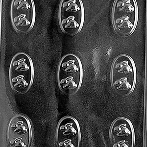 May include: A clear plastic chocolate mould. The mould has nine oval cavities, each with two bunny rabbit designs. The words "LINE OF BEAUTY A 62" are printed at the bottom of the mould.