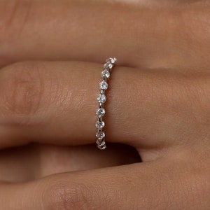 Op de afbeelding: Een delicate eeuwigheidsring met een rij kleine, ronde diamanten gezet in een witgouden band.