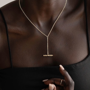 Organic shaped bar hanging from a lariat style necklace. The fluid  or undulating shape is very natural if form. The  necklace layers perfectly with other chains as well.