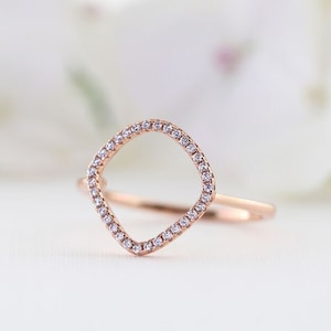May include: A rose gold ring with a diamond-encrusted open circle design.
