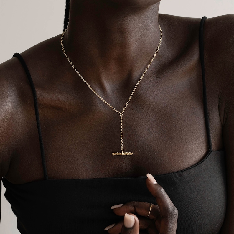 Organic shaped bar hanging from a lariat style necklace. The fluid  or undulating shape is very natural if form. The  necklace layers perfectly with other chains as well.