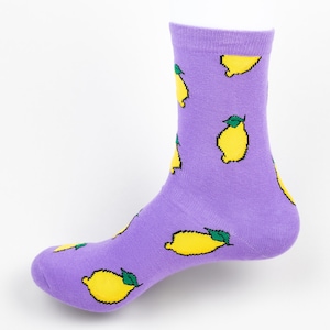 Könnte beinhalten: Lilafarbene Socken mit einem Zitronenmuster. Die Zitronen sind gelb mit grünen Blättern.
