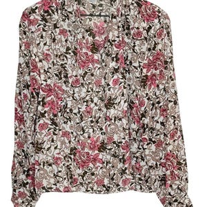 May include: A long-sleeved button-down shirt featuring a white base with a repeating floral pattern in shades of pink and dark brown. The garment has a pointed collar, a full-length front button closure, and buttoned cuffs on the sleeves.