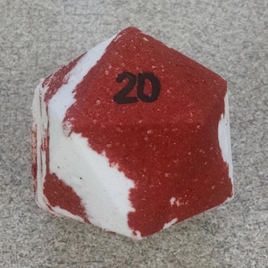 May include: A red and white geometric object with the number 20 in black. The object has a textured surface and a unique shape, possibly a decorative item or a game piece.