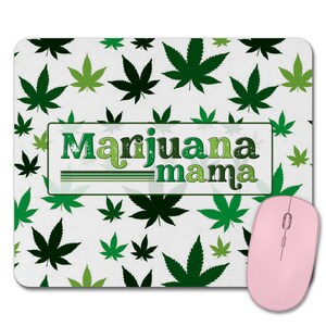 May include: A white mouse pad with a green marijuana leaf pattern and the text "Marijuana mama" in a vintage style font.