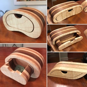 Könnte beinhalten: Eine handgefertigte Holzschmuckschatulle mit einem einzigartigen, geschwungenen Design. Die Schatulle besteht aus mehreren Holzschichten in verschiedenen Braun- und Beigetönen mit einer kleinen Schublade. Die Schatulle ist etwa 20 cm lang.