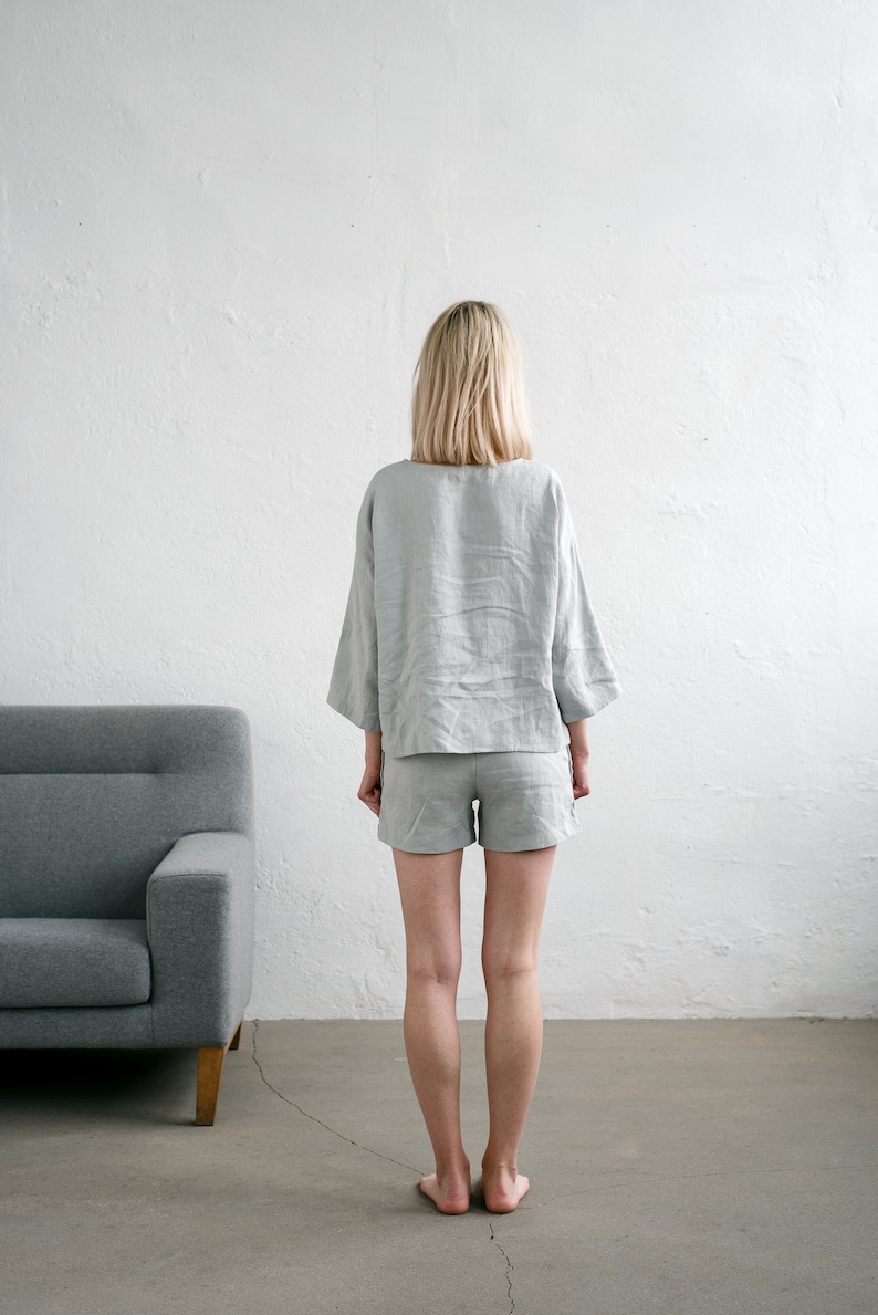 May include: A person wearing a light grey linen shorts set. The set includes a short-sleeved top and shorts.