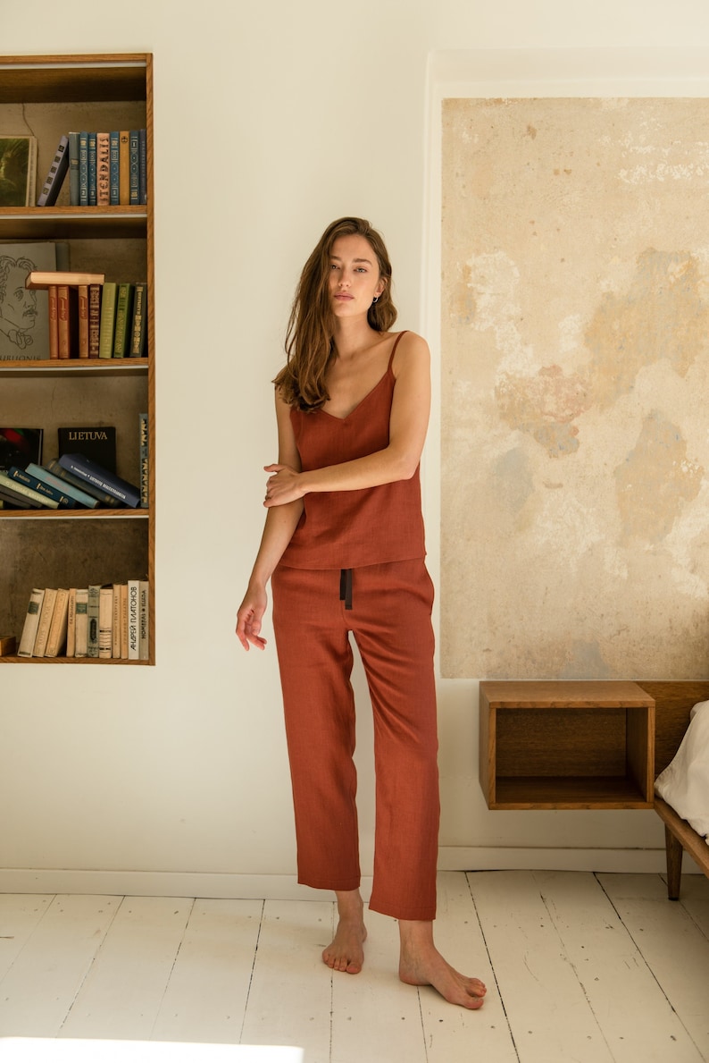 Puede incluir: Una mujer lleva un pijama de lino de color &oacute;xido. El conjunto incluye una camiseta sin mangas y pantalones anchos.