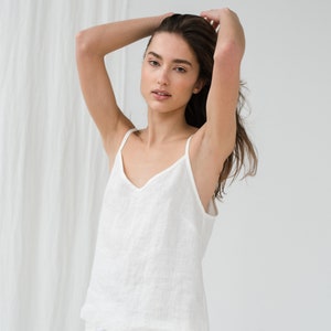 Peut inclure: Un haut de r&eacute;servoir en lin blanc et un pantalon assorti. Le haut de r&eacute;servoir a un col en V et le pantalon a une taille &agrave; cordon.