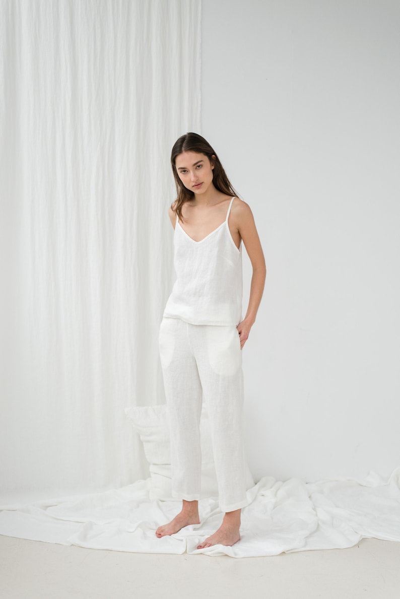 Peut inclure: Un haut de r&eacute;servoir en lin blanc et un pantalon assorti. Le haut de r&eacute;servoir a un col en V et le pantalon a des poches.