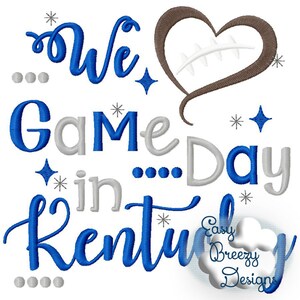 May include: Embroidered design featuring the text "We Game Day in Kentucky" in blue and gray lettering with a brown heart with a white stitched football inside. The design also includes small white stars and dots.