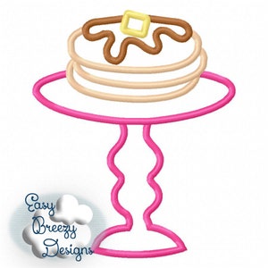 May include: A pink stand with a wavy base holds a stack of three brown pancakes with a brown swirl of syrup and a yellow square of butter on top.