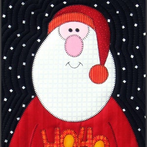 Op de afbeelding: Een rode en witte gestikte kerstman met een witte baard en een rode muts. De kerstman draagt een rode trui met het woord "HO HO HO" in oranje en gele letters.