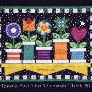 Puede incluir: Un fondo a cuadros blanco y negro con un borde verde. Una fila de flores de tela coloridas en carretes de hilo con nombres en cada flor. El texto "Sew Glads" está en una pancarta amarilla. El texto "Friends Are The Threads That Bind" está en la parte inferior de la imagen.