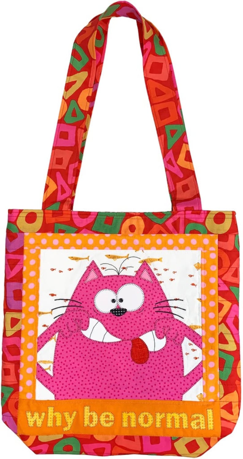 May include: A red, orange, green, and pink tote bag with a whimsical pink cat with a red tongue sticking out. The cat is surrounded by orange and white polka dots and gold fish. The bag has a white background with the text "why be normal" in yellow letters.