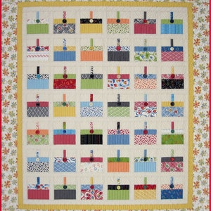 May include: A quilt with a patchwork design featuring a variety of colorful fabrics. The quilt is made up of squares, each with a different pattern. The quilt is bordered with a floral print.