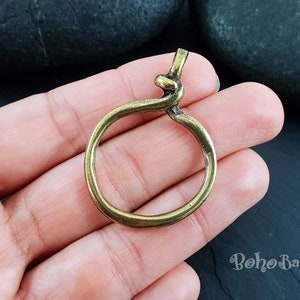 May include: A gold-toned metal ring with a knotted design. The ring is about 2 inches in diameter and has a smooth, polished finish.