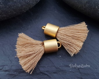 May include: Two gold tassel ends with a brown tassel fringe. The tassel ends are made of metal and have a smooth, matte finish.