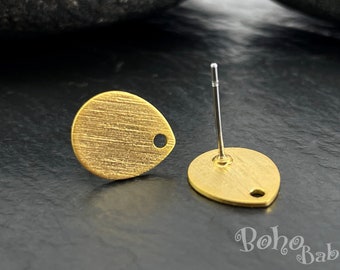 May include: A pair of gold-toned teardrop-shaped earring studs with a brushed finish. The earrings have a small hole at the top for attaching to a post.