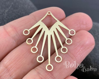 May include: Gold metal pendant with a fan-shaped design and multiple circular cutouts. The pendant has a loop at the top for attaching a chain or cord.