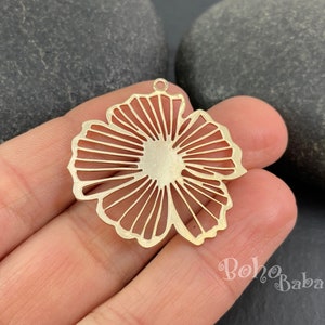 May include: Gold metal flower charm with a delicate, intricate design. The charm has a hole at the top for attaching to jewellery or other crafts.