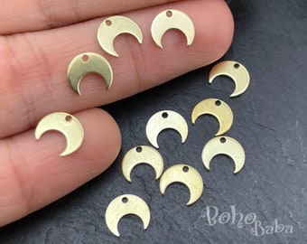 May include: A collection of 10 gold-toned metal crescent moon charms with a hole at the top for attaching to jewelry or other crafts.