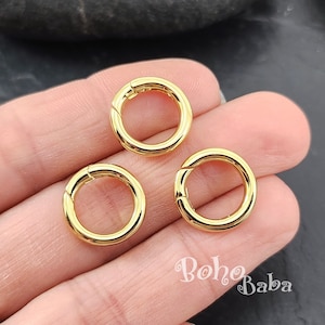 Puede incluir: Tres anillos de salto de metal dorado, cada uno con un cierre de resorte. Los anillos tienen un diámetro de aproximadamente 2,5 cm.