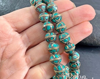 May include: A double strand of turquoise and gold beads. The beads are round and have a decorative pattern. The beads are strung on a cord and are tied together at the ends.