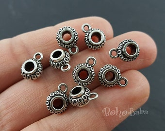 May include: Silver tone metal bead caps with a decorative design and a loop for attaching to jewelry. The bead caps are approximately 1/2 inch in diameter.