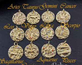 May include: Twelve gold zodiac charms with colourful gemstones. Each charm features a different zodiac symbol, including Aries, Taurus, Gemini, Cancer, Leo, Virgo, Libra, Scorpio, Sagittarius, Capricorn, Aquarius, and Pisces. The charms are arranged in three rows of four, with the text "Boho Baba" at the bottom.