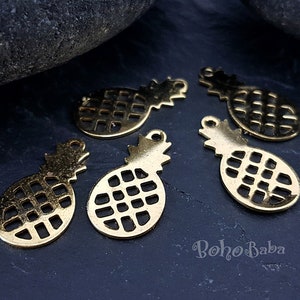May include: Five gold-coloured metal pineapple charms with a cutout design. The charms have a loop at the top for attaching to jewellery or other crafts.