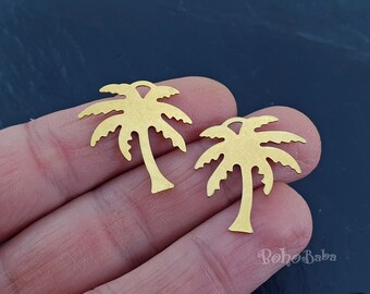 May include: Two gold-colored palm tree charms. Each charm features a detailed palm tree design with a trunk and fronds. The charms are likely for jewelry making or crafting projects.