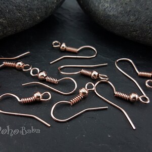May include: A close-up of rose gold earring hooks. The hooks are made of metal and have a spring-loaded closure. They are perfect for making your own earrings.