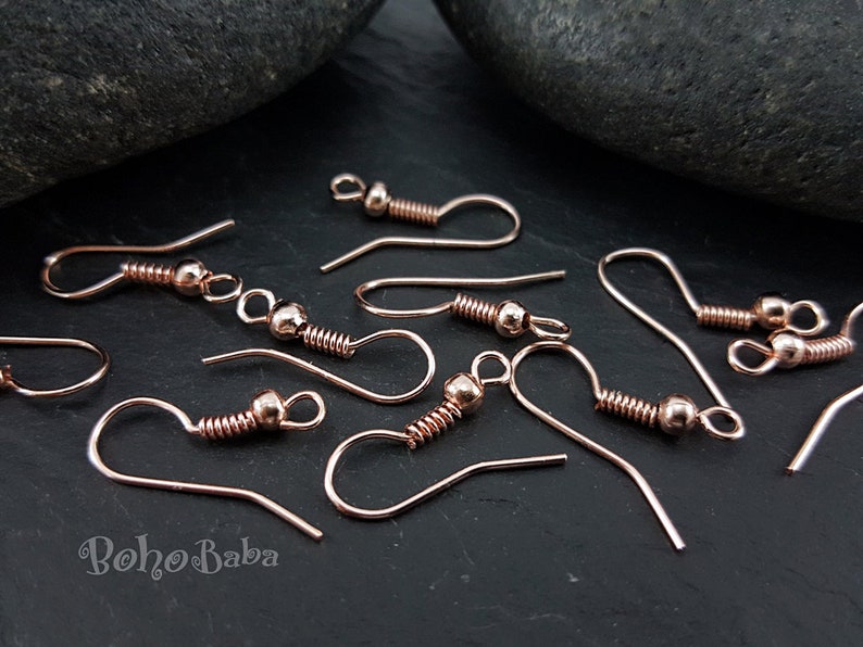 May include: A close-up of rose gold earring hooks. The hooks are made of metal and have a spring-loaded closure. They are perfect for making your own earrings.