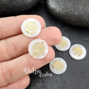 May include: Circular, white mother-of-pearl beads featuring a gold-coloured tree of life design. Each bead has a small hole for threading. The beads are from Boho Baba.