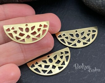 May include: Three gold metal half-circle charms with a geometric design. The charms have a hole at the top for hanging.