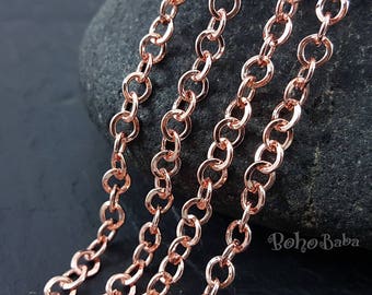 May include: Three strands of rose gold chain, each with a different length, are displayed against a dark gray background. The chains are made of small, round links.