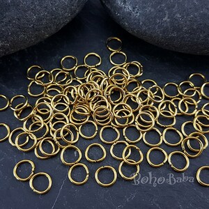 May include: A large pile of gold jump rings, perfect for jewelry making or crafting projects.