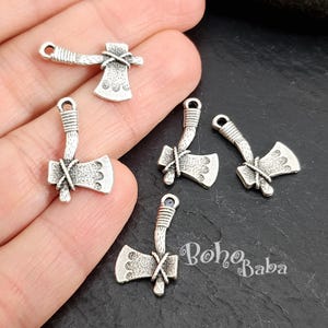 May include: Five silver axe charms with a textured surface and a rope detail. The charms have a loop at the top for attaching to jewellery or other crafts.