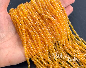 May include: A strand of small, faceted, amber-colored glass beads. The beads are strung on a clear thread and have a slight iridescent shimmer.