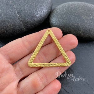 May include: Gold triangle pendant with a hammered texture and a hole at the top for hanging.